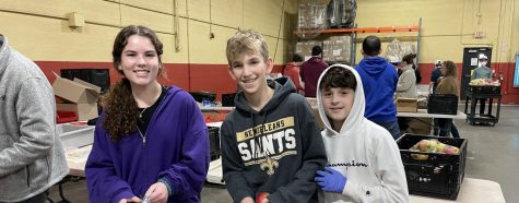 HBHA students flash a smile as they bag apples at Harvesters. Photo by Aviva Clauer