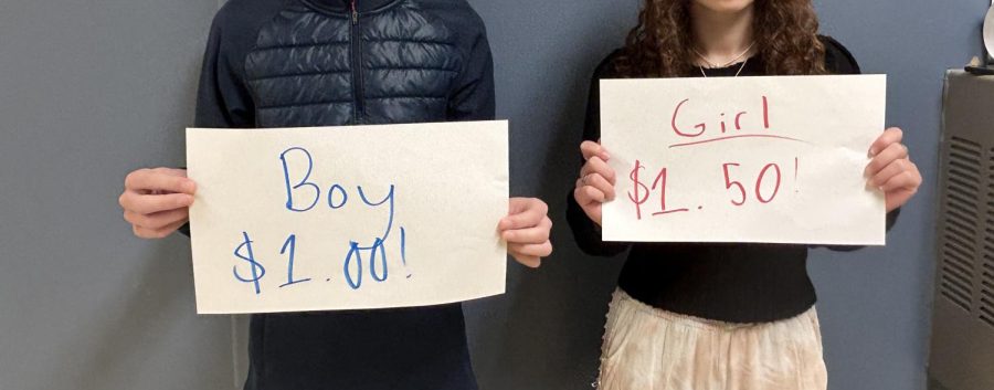 A+male+and+a+female+student+holding+a+sign+symbolizing+the+extra+retail+tax+for+women.+Photo+by+Avital+Mullokandova.+