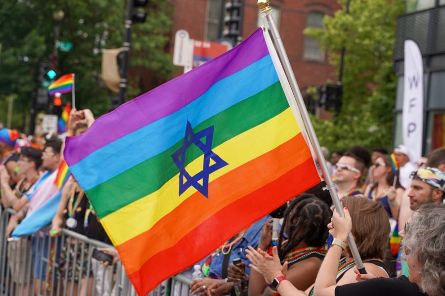 Jewish-star embossed pride flag is waved during a pride parade. Image by hiddush.org