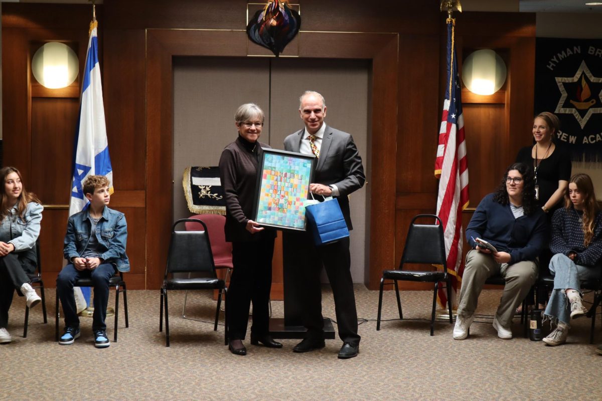 Head of school, Adam Tilove, Governor Kelly a piece of alumna art work. The piece displays the prayer for peace in Hebrew, which translates to “Grant peace, welfare, blessing,​​ grace, loving kindness and mercy unto us and unto all Israel, your people.”