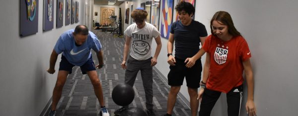 Hinkle demonstrates how to slam medicine balls with high school students.