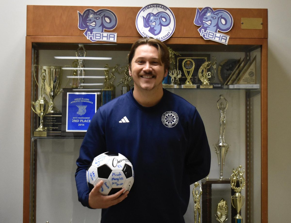 Ness is holding a soccer ball that HBHA students and faculty signed as a welcoming gift when he first came to HBHA. Photo by Rhys Pabst.
